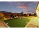 Backyard featuring artificial turf, patio area with lounge chairs and landscaping at 23145 E Stonecrest Dr, Queen Creek, AZ 85142
