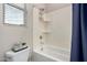 Well-lit bathroom with shower-tub combo, a single window, and toilet with shelving at 23145 E Stonecrest Dr, Queen Creek, AZ 85142