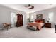 Spacious bedroom with plush carpeting, ceiling fan, and a decorative armoire at 23145 E Stonecrest Dr, Queen Creek, AZ 85142