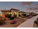 Charming single-story home with well-manicured front yard and walkway lighting, creating a warm ambiance at 23145 E Stonecrest Dr, Queen Creek, AZ 85142