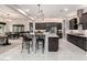 Modern kitchen featuring an island with bar seating and pendant lighting, complemented by sleek, dark cabinetry at 23145 E Stonecrest Dr, Queen Creek, AZ 85142