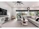 Spacious living room featuring an oversized sectional, complemented by natural light and modern ceiling fan at 23145 E Stonecrest Dr, Queen Creek, AZ 85142