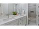 Elegant bathroom featuring double sinks with marble countertop, brushed nickel faucets, and a tiled shower in the background at 2317 N Steele Cir, Mesa, AZ 85207