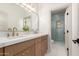 Well-lit bathroom featuring a double sink vanity with bronze fixtures and a glass shower enclosure at 2578 E Arrowhead Trl, Gilbert, AZ 85297