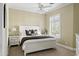 Bright and airy bedroom with a white wood frame bed, ceiling fan, and plantation shutters at 315 S Racine Ct, Gilbert, AZ 85296