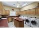 Spacious laundry room featuring two sets of washer and dryer, wood cabinets, and workspace at 315 S Racine Ct, Gilbert, AZ 85296