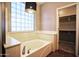 Relaxing bathroom featuring a soaking tub and decorative window at 35210 N 34Th Ln, Phoenix, AZ 85086