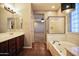 Spacious bathroom featuring a double vanity, soaking tub, and decorative lighting at 35210 N 34Th Ln, Phoenix, AZ 85086
