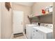 Well-equipped laundry room with modern washer and dryer, shelving, and tiled floor at 35293 N Thurber Rd, San Tan Valley, AZ 85144