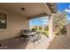 Covered patio is perfect for outdoor dining, with a view of the manicured backyard at 35293 N Thurber Rd, San Tan Valley, AZ 85144