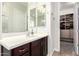 Bathroom with walk-in closet, dark wood vanity, and Hollywood light fixture at 3556 E Ivanhoe St, Gilbert, AZ 85295