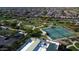 Aerial view of community tennis courts, park, and green space with lush trees at 3751 N Hidden Canyon Dr, Florence, AZ 85132