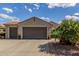 Attractive front exterior showcasing a three car garage, desert landscaping, and a terracotta roof at 3751 N Hidden Canyon Dr, Florence, AZ 85132