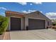 Front exterior highlighting a three-car garage with a well-maintained driveway and desert landscaping at 3751 N Hidden Canyon Dr, Florence, AZ 85132