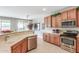 Kitchen with wood cabinets, stainless appliances, and breakfast bar overlooking dining area at 3751 N Hidden Canyon Dr, Florence, AZ 85132