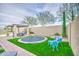 Lush backyard featuring a trampoline, seating, and a covered patio, perfect for outdoor entertaining at 4207 S Electron --, Mesa, AZ 85212