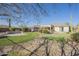 A lush backyard oasis with a private putting green, pool, and seating area at 4243 S Hackberry Trl, Gold Canyon, AZ 85118
