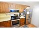 Functional kitchen featuring wood cabinets, stainless steel appliances, and laminate flooring at 4328 E Capri Ave # 171, Mesa, AZ 85206