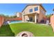 Expansive backyard with artificial grass, a pool, covered patio, and a fire pit, perfect for entertaining at 44115 W Palmen Dr, Maricopa, AZ 85138