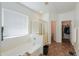 Primary bathroom featuring a separate tub, shower, and walk-in closet at 44115 W Palmen Dr, Maricopa, AZ 85138
