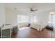 Bright bedroom with wood floors, ceiling fan, and natural light from two windows at 44115 W Palmen Dr, Maricopa, AZ 85138