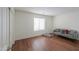 Bedroom with a gray futon, a closet, wood floors, and a window with blinds at 44115 W Palmen Dr, Maricopa, AZ 85138