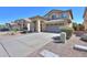 Charming home exterior with a tile roof, two-car garage and desert landscaping on a sunny day at 44115 W Palmen Dr, Maricopa, AZ 85138