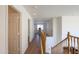 Upstairs hallway with hardwood floors and railing overlooking the living area at 44115 W Palmen Dr, Maricopa, AZ 85138