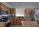 Well-equipped kitchen featuring stainless steel appliances, ample counter space, and wood cabinetry at 44115 W Palmen Dr, Maricopa, AZ 85138