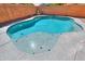 Beautiful in-ground pool with a beach entry and water features, surrounded by a concrete patio at 44115 W Palmen Dr, Maricopa, AZ 85138