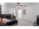 Bright bedroom with a ceiling fan features neutral walls, grey carpeting, and a door to another room at 44165 W Kramer Ln, Maricopa, AZ 85138