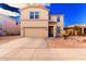 Two-story home showcasing a well-kept yard, two-car garage, and desert-friendly landscaping at 44165 W Kramer Ln, Maricopa, AZ 85138