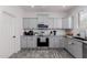A modern kitchen with gray cabinets, stainless steel appliances, and subway tile backsplash at 44165 W Kramer Ln, Maricopa, AZ 85138