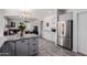 Open kitchen area with gray cabinetry, stainless steel refrigerator, and an island at 44165 W Kramer Ln, Maricopa, AZ 85138