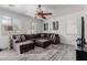 Spacious living room with a large sectional sofa, ceiling fan, and neutral decor at 44165 W Kramer Ln, Maricopa, AZ 85138