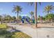 Outdoor playground with slides, climbing structures, mature palm trees, and a shaded picnic area at 44165 W Kramer Ln, Maricopa, AZ 85138