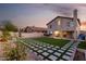Backyard featuring new grass, stone pavers, and mature landscaping at dusk at 4720 E Adobe Dr, Phoenix, AZ 85050