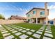 Expansive backyard featuring lush artificial turf, decorative pavers, and a patio area for outdoor entertaining at 4720 E Adobe Dr, Phoenix, AZ 85050