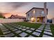 The home's expansive backyard showcases a modern stone pathway amidst vibrant green grass, perfect for outdoor enjoyment at 4720 E Adobe Dr, Phoenix, AZ 85050