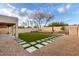 Backyard with artificial grass, pavers, mature desert landscaping, and privacy walls at 4720 E Adobe Dr, Phoenix, AZ 85050