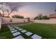 A stunning backyard features a patterned walkway through lush green grass, creating a picturesque outdoor space at 4720 E Adobe Dr, Phoenix, AZ 85050