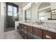 Luxury bathroom featuring dual sinks, custom wood cabinets, and a glass-enclosed shower at 4720 E Adobe Dr, Phoenix, AZ 85050