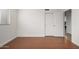 This bedroom has wood laminate flooring and a closet with white sliding doors, leading to more rooms in the house at 4720 E Adobe Dr, Phoenix, AZ 85050