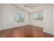 Bedroom with neutral walls, wood floors, ceiling fan, and two windows at 4720 E Adobe Dr, Phoenix, AZ 85050