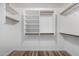 Bright white walk-in closet with built-in shelving and wood floors at 4720 E Adobe Dr, Phoenix, AZ 85050