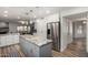Kitchen featuring an island with granite countertop, stainless steel refrigerator, and white cabinets at 4720 E Adobe Dr, Phoenix, AZ 85050