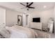 Bedroom with a ceiling fan, dresser, mirrors, and a view into another room at 5114 E Hartford Ave, Scottsdale, AZ 85254