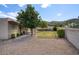 Well-maintained backyard with gravel, mature trees, and a grassy area at 536 W Surrey Ave, Phoenix, AZ 85029