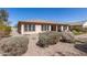 Backyard showing gravel landscaping, low shrubs, and an outdoor living space with a covered patio at 5721 W Molly Ln, Phoenix, AZ 85083