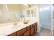 Stylish bathroom with double sinks, wooden cabinets, modern fixtures, and decorative vases at 5721 W Molly Ln, Phoenix, AZ 85083